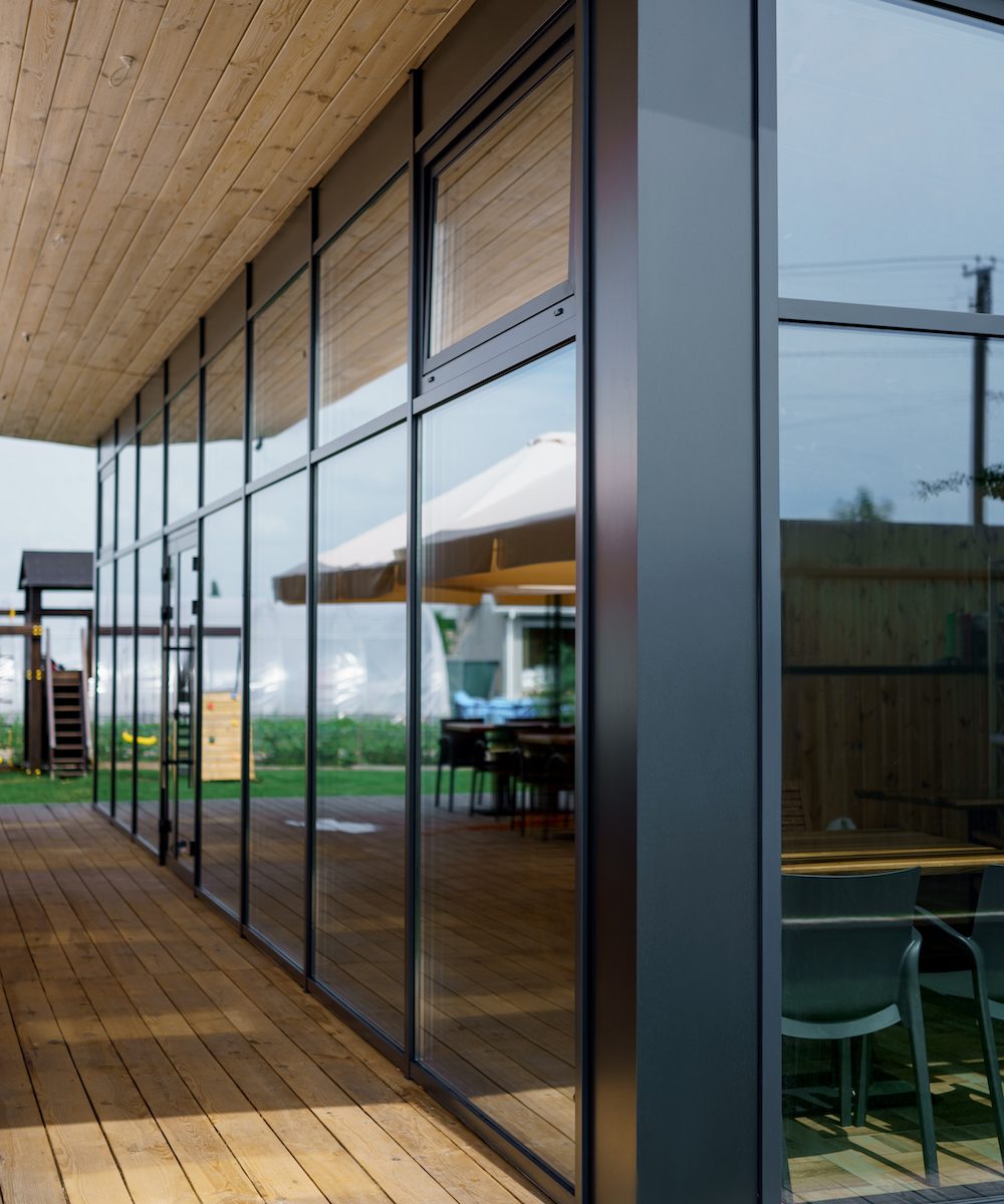 Elegant wooden home terrace with balcony. doors from bathroom and bedroom. Panorama of spacious terrace with wooden floor and furniture and amazing view.