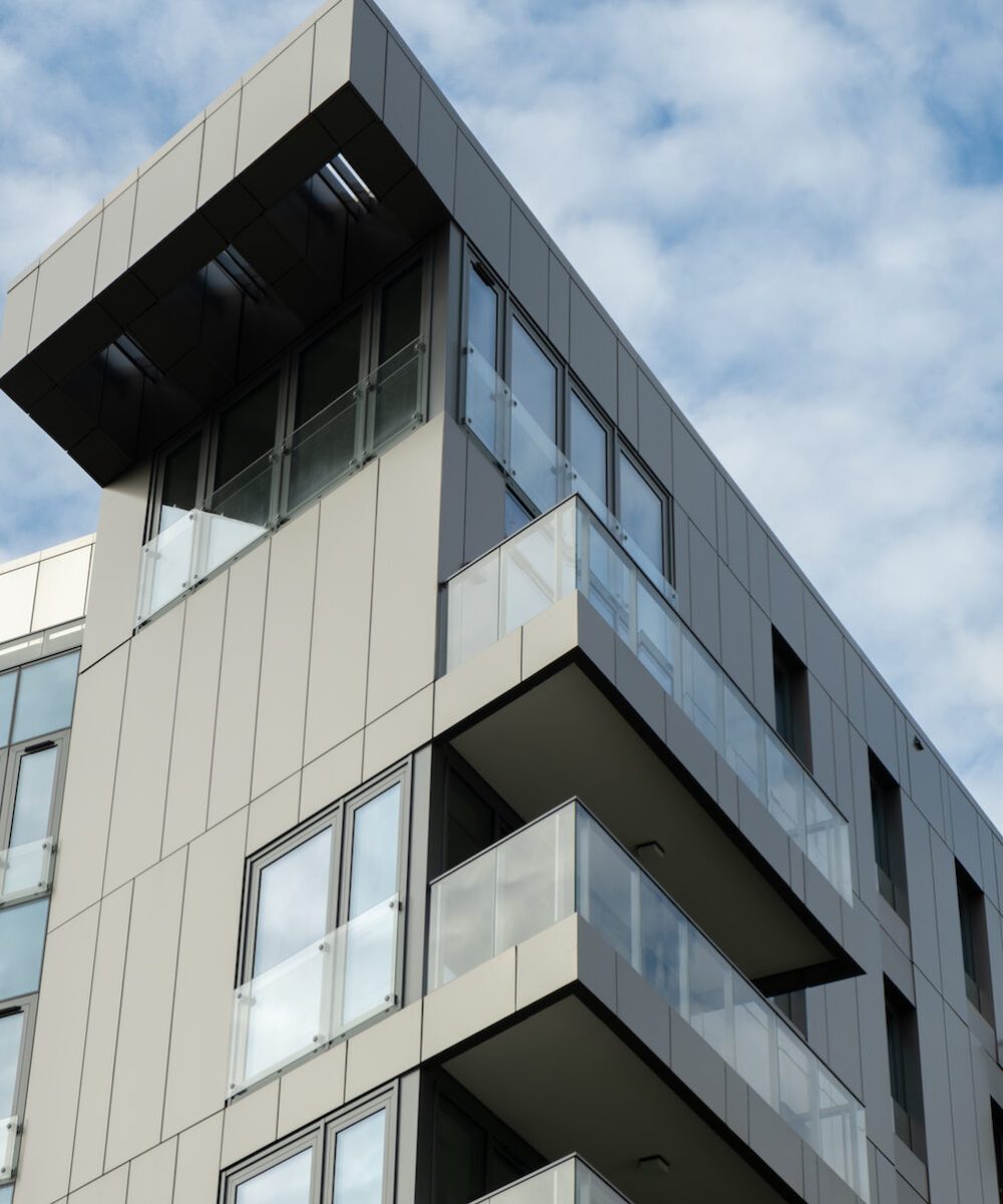 Modern office building exterior with glass facade on clear sky background. Transparent glass wall of office building with yellow decoration. Element of facade of modern European building Commercial office buildings. Abstract modern business architecture